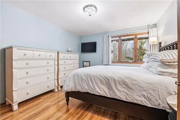 a bedroom with a bed and a flat tv screen on dresser