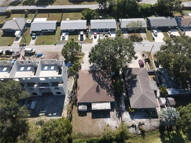 a aerial view of a house with a yard and large tree