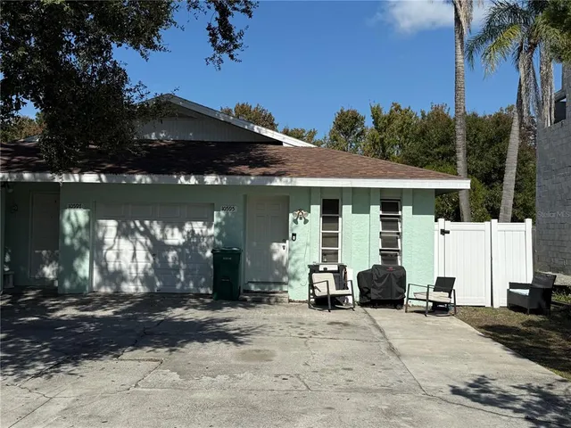 a view of a house with patio next to a yard