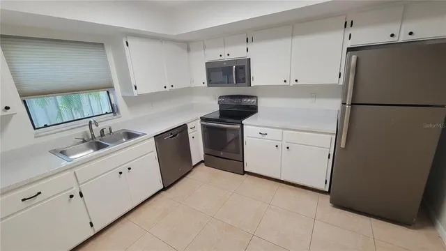 a kitchen with white cabinets and white appliances