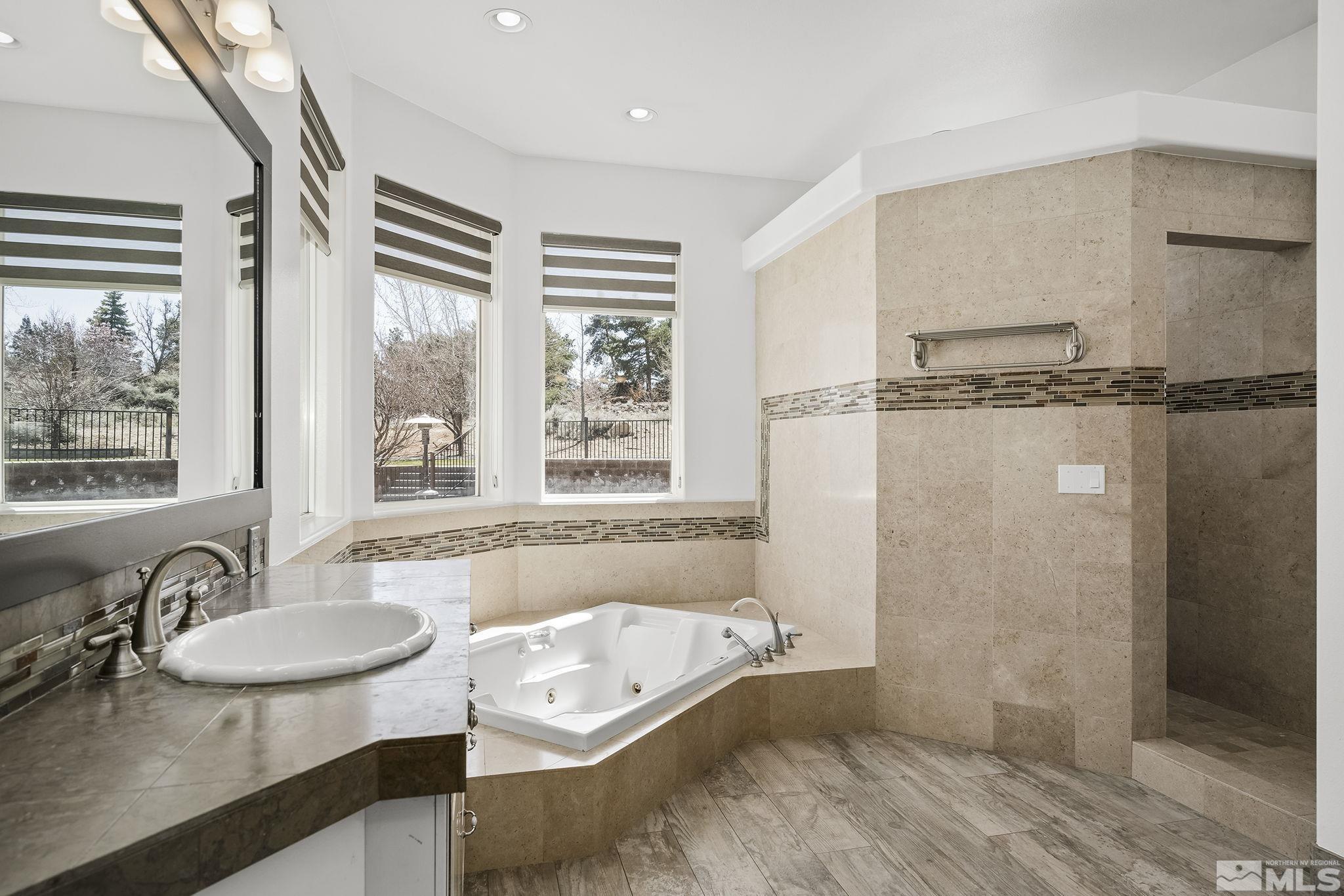 4900 Gallup Road Reno, NV 89511 - Photo 16 of 38 a bathroom with a tub sink and mirror
