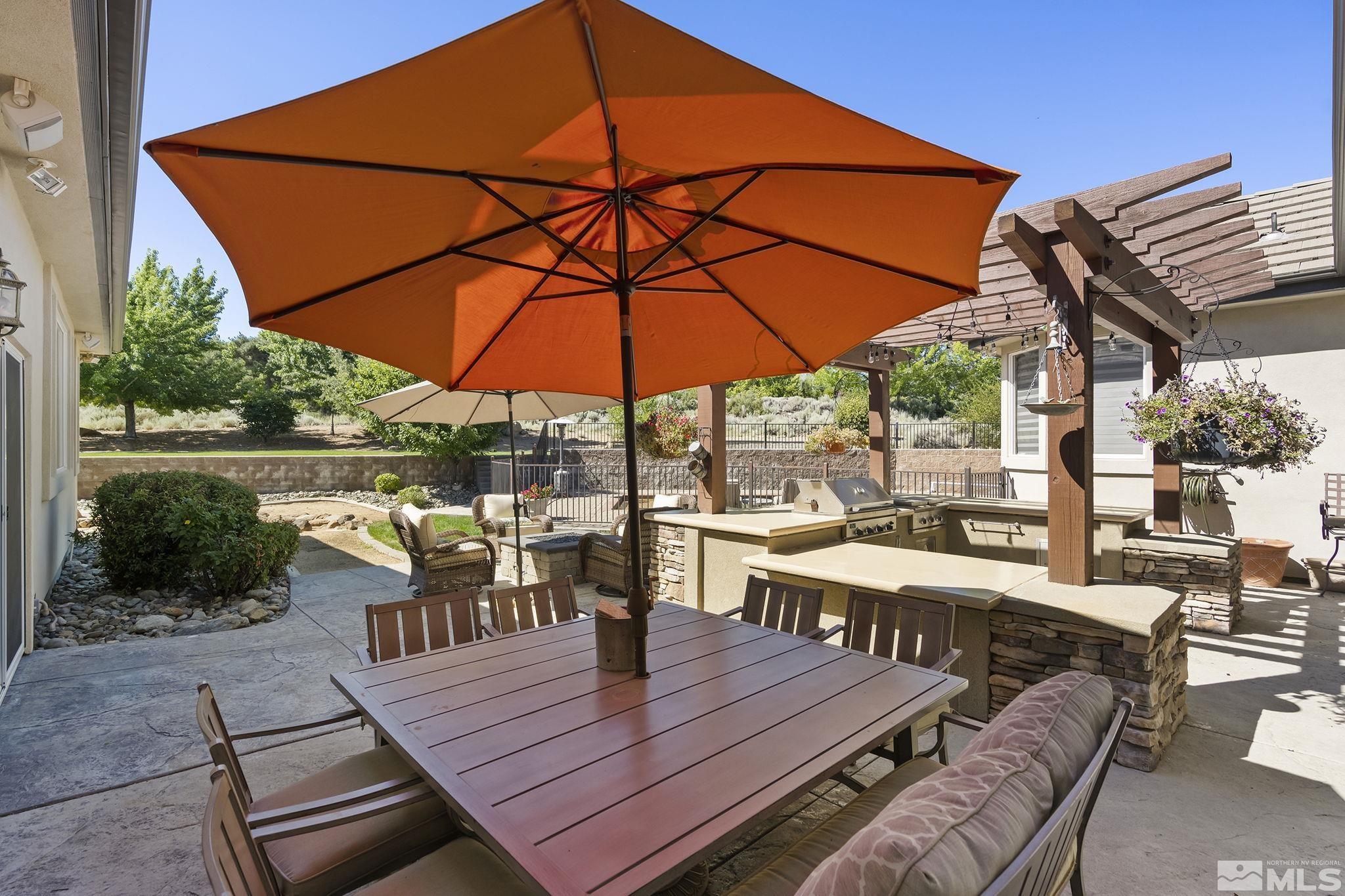 4900 Gallup Road Reno, NV 89511 - Photo 24 of 38 a view of a roof deck with table and chairs under an umbrella