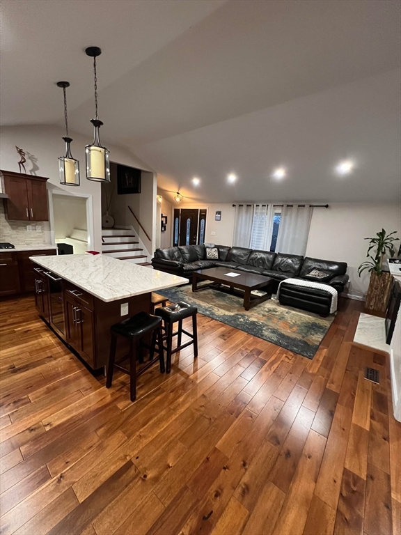 a kitchen with stainless steel appliances granite countertop a stove a sink dishwasher and a microwave oven with cabinets