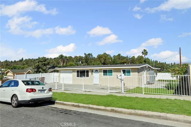a view of a white house with a back yard