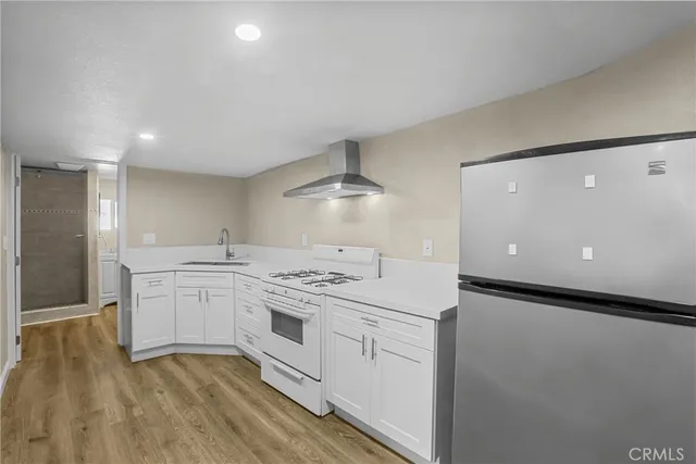 a kitchen with kitchen island stainless steel appliances a sink stove and refrigerator