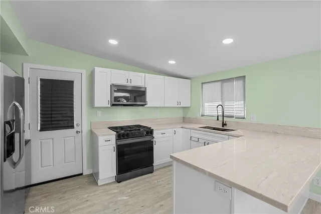 a kitchen with kitchen island a sink stainless steel appliances and cabinets