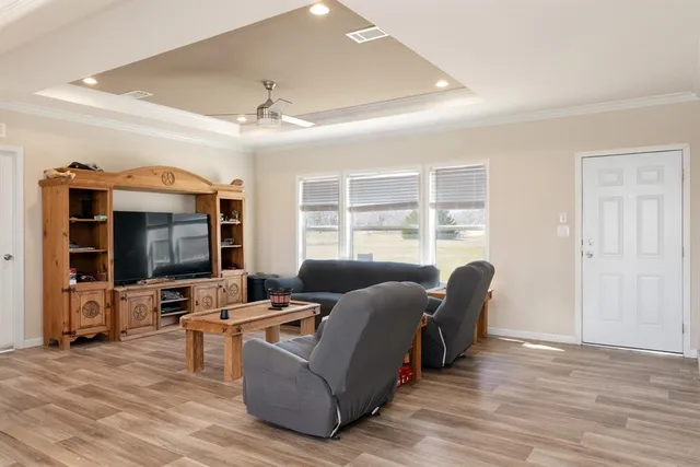 a living room with furniture flat screen tv and windows