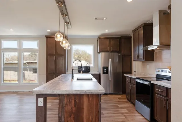 a kitchen with stainless steel appliances a sink stove and refrigerator