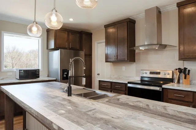 a kitchen with stainless steel appliances granite countertop a sink refrigerator stove and microwave