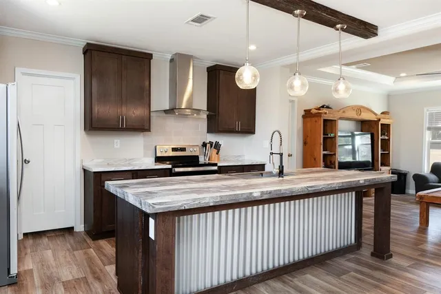 a kitchen with stainless steel appliances granite countertop a stove a sink and a refrigerator