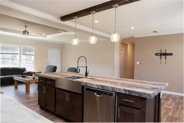 a kitchen with stainless steel appliances granite countertop a sink a stove and a wooden floor