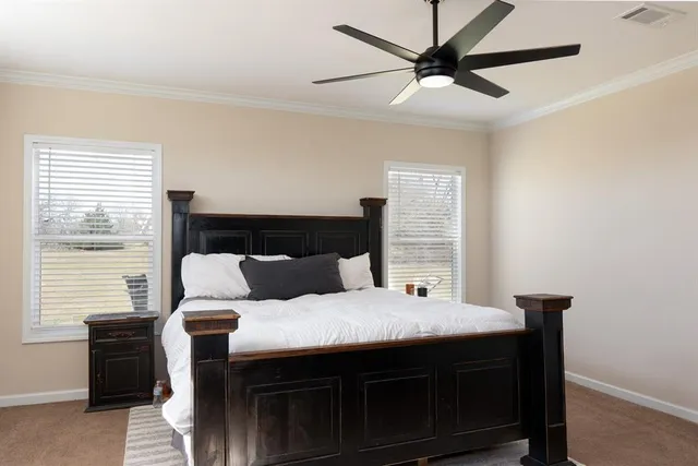 a bed sitting in a bedroom next to a window