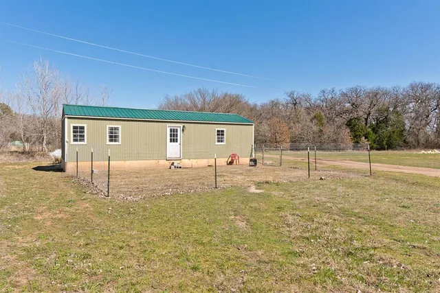 a backyard of a house with table and chairs
