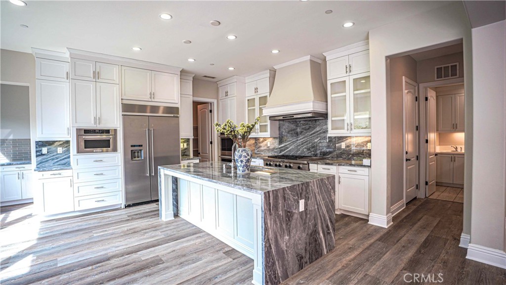 61 Windwalker Way Tustin, CA 92782 - Photo 5 of 16 a kitchen with stainless steel appliances kitchen island granite countertop a refrigerator and a stove top oven