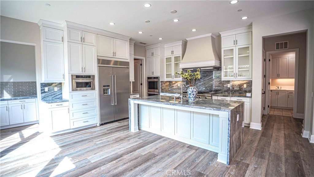 61 Windwalker Way Tustin, CA 92782 - Photo 7 of 16 a kitchen with stainless steel appliances granite countertop a refrigerator and a stove top oven