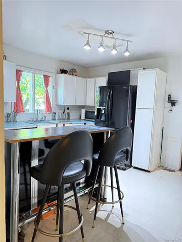 a kitchen with stainless steel appliances granite countertop a table chairs refrigerator a sink and dishwasher a oven with wooden floor