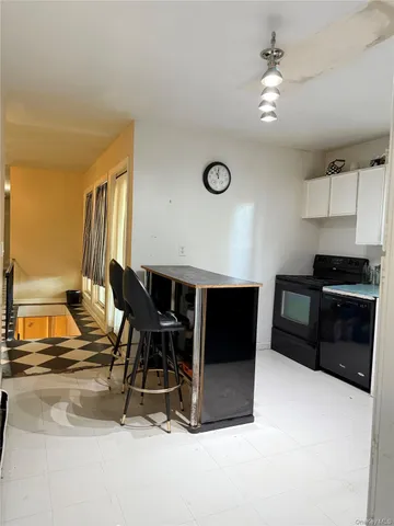 a living room with a table chairs and a kitchen view