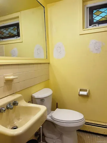 a bathroom with a sink and mirror with toilet