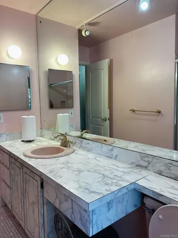 a bathroom with a granite countertop sink and a mirror
