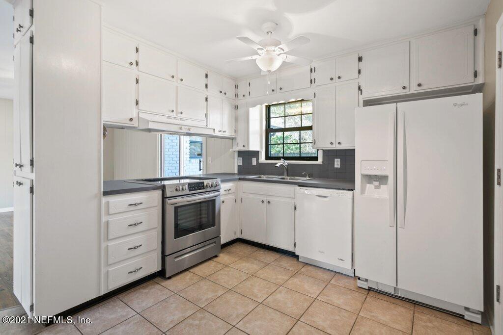 5115 Brighton Drive Jacksonville, FL 32217 - Photo 12 of 37 a kitchen with white cabinets and white appliances
