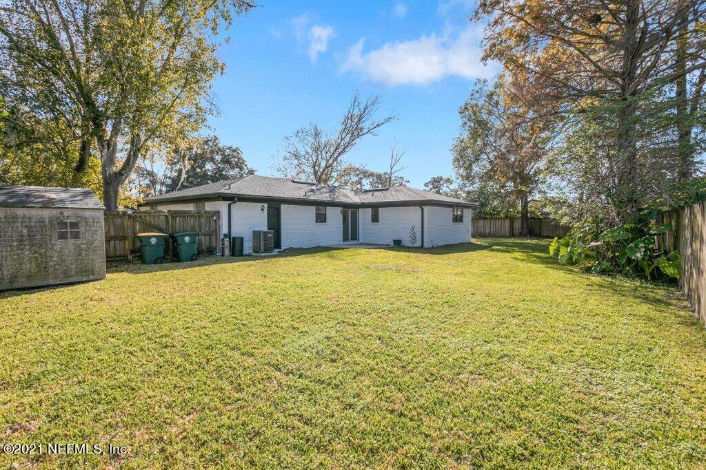 5115 Brighton Drive Jacksonville, FL 32217 - Photo 34 of 37 a blue swimming pool is in a backyard of a house