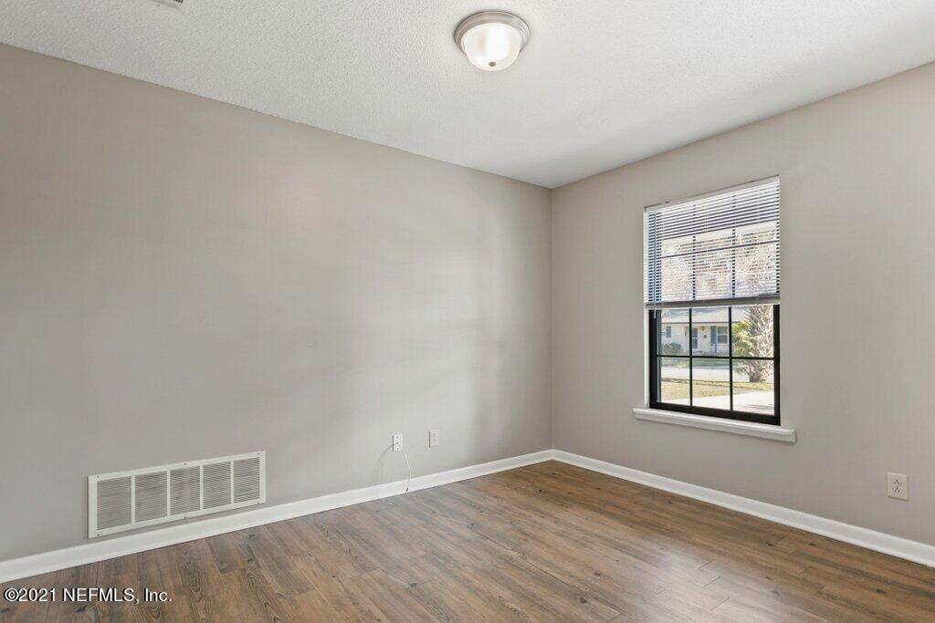5115 Brighton Drive Jacksonville, FL 32217 - Photo 9 of 37 an empty room with wooden floor and windows