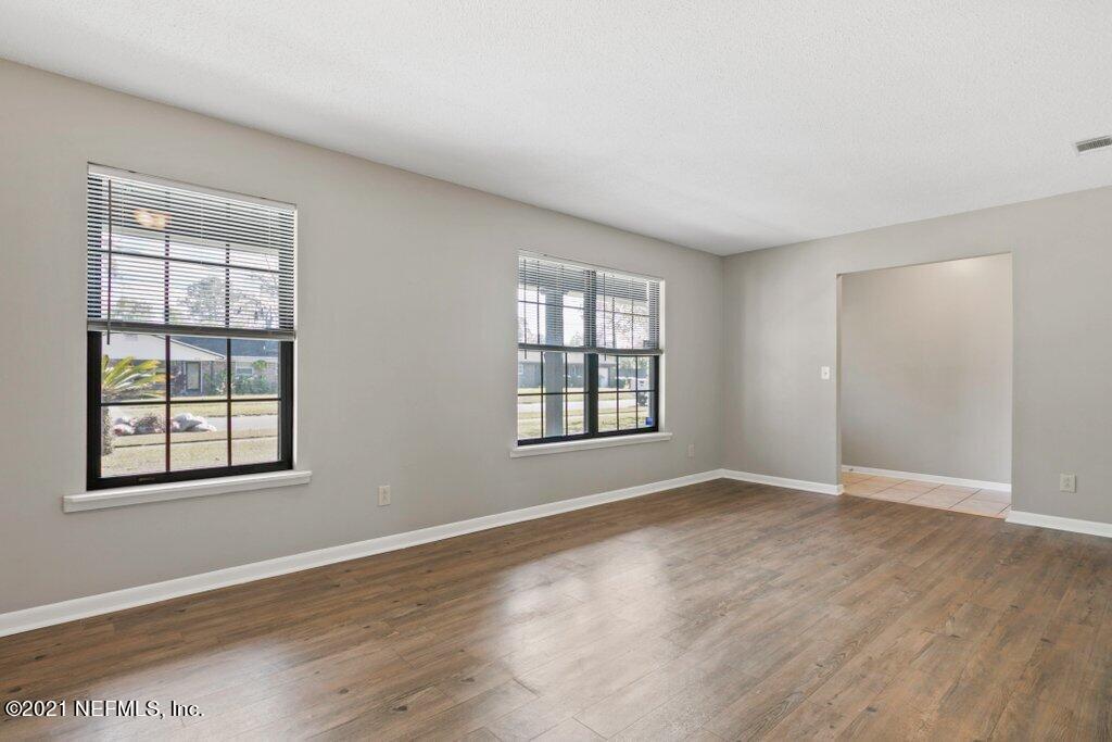 5115 Brighton Drive Jacksonville, FL 32217 - Photo 10 of 37 an empty room with wooden floor and windows