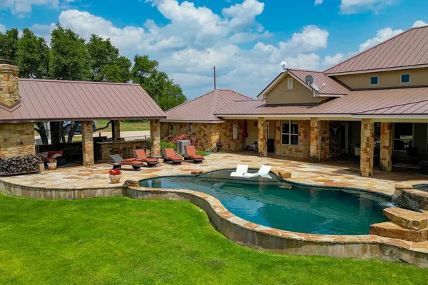 a view of a house with swimming pool and sitting area