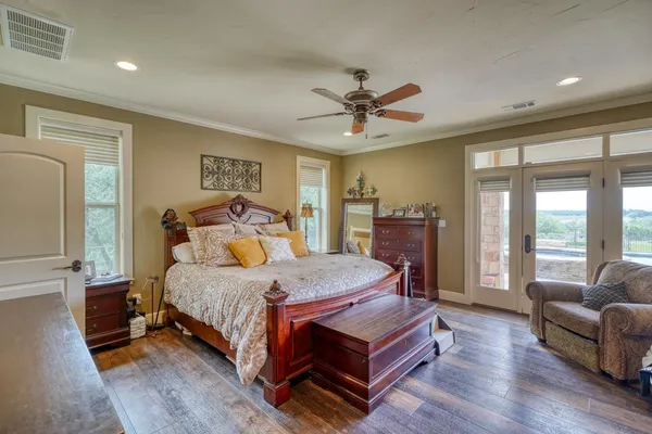 a bedroom with a bed a couch and a chandelier