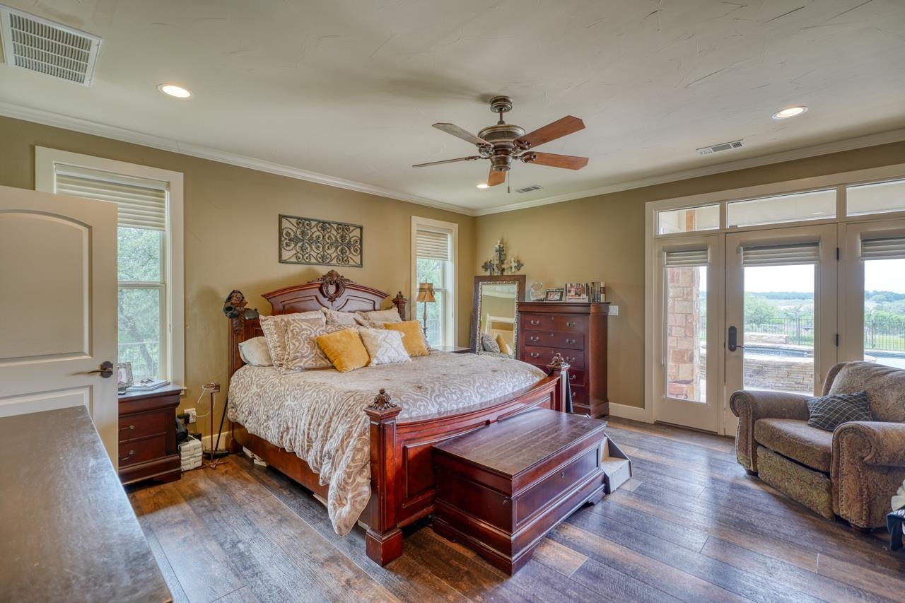 791 Ranch Road 2323 Llano, TX 78643 - Photo 10 of 30 a bedroom with a bed a couch and a chandelier