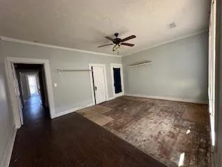 a view of empty room with wooden floor and ceiling fan
