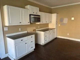 a kitchen with white cabinets and sink