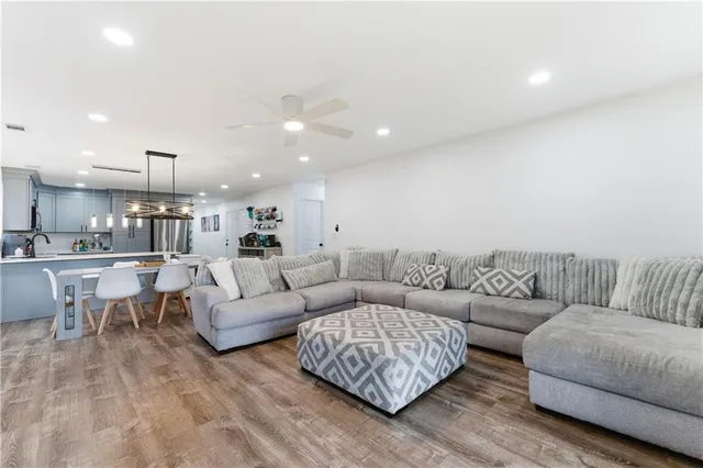 a living room with furniture and a view of kitchen