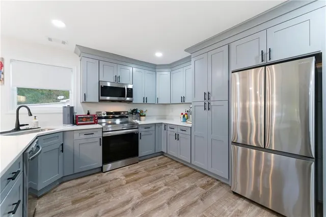 a kitchen with a refrigerator a sink a stove a microwave and cabinets