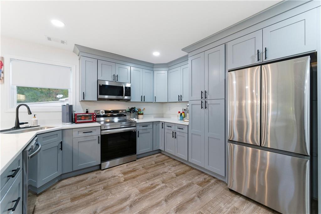 62 Dude Street Northwest Rome, GA 30165 - Photo 7 of 22 a kitchen with a refrigerator a sink a stove a microwave and cabinets