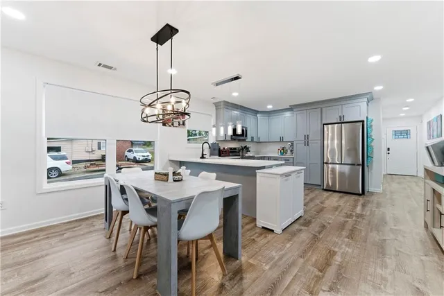 a kitchen with a table chairs refrigerator and cabinets