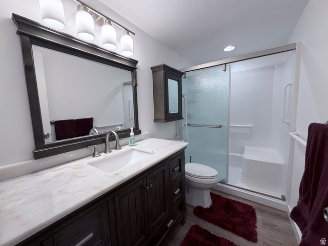2855 South 1000 West Perry, UT 84302 - Photo 140 of 142 Full bathroom with vanity, a shower stall, and dark wood-style flooring