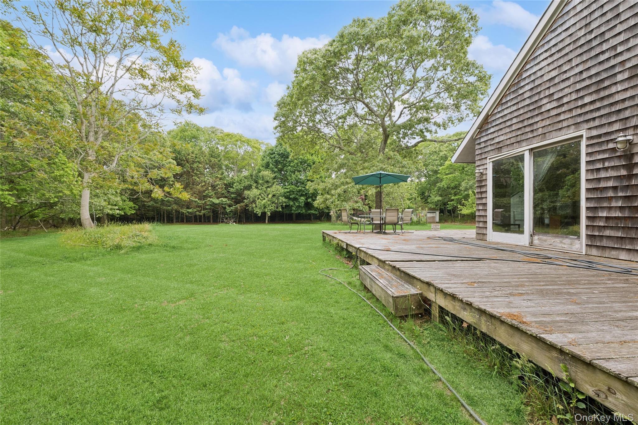 131 Red Creek Road Hampton Bays, NY 11946 - Photo 4 of 35 a view of a backyard with a garden