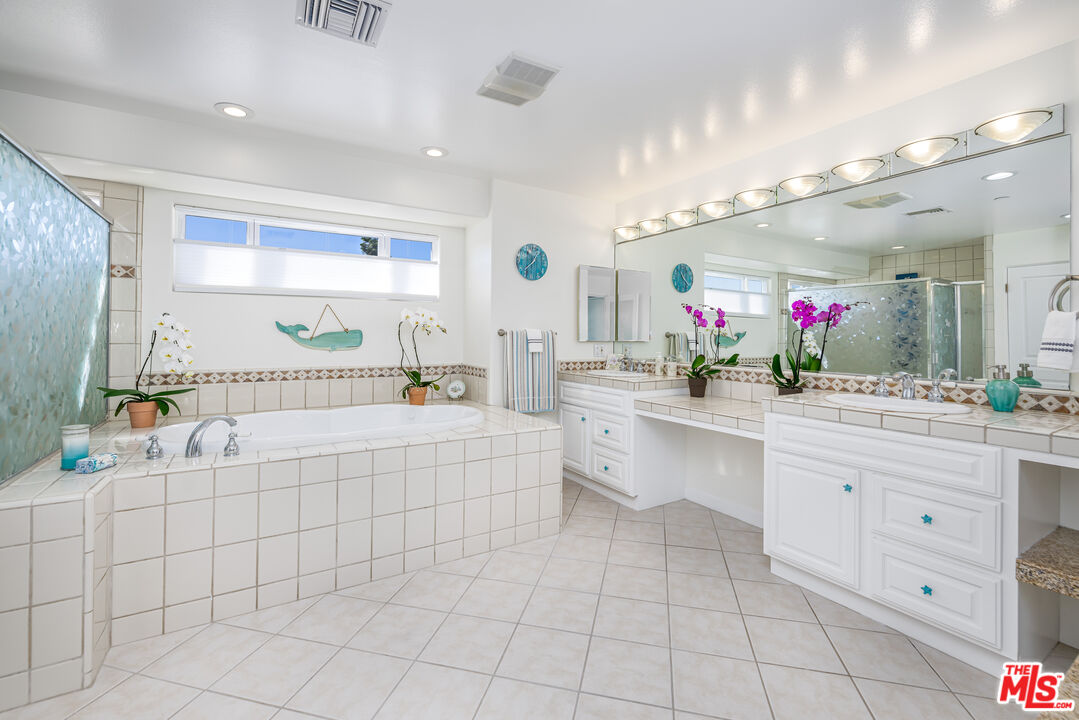 5101 Breakwater Way Oxnard, CA 93035 - Photo 19 of 39 a spacious en suite bathroom with a granite countertop sink mirror and bathtub