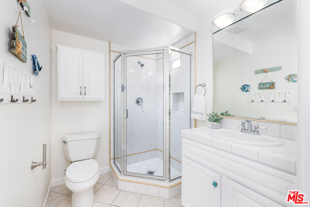 5101 Breakwater Way Oxnard, CA 93035 - Photo 28 of 39 a bathroom with a granite countertop sink a toilet and shower