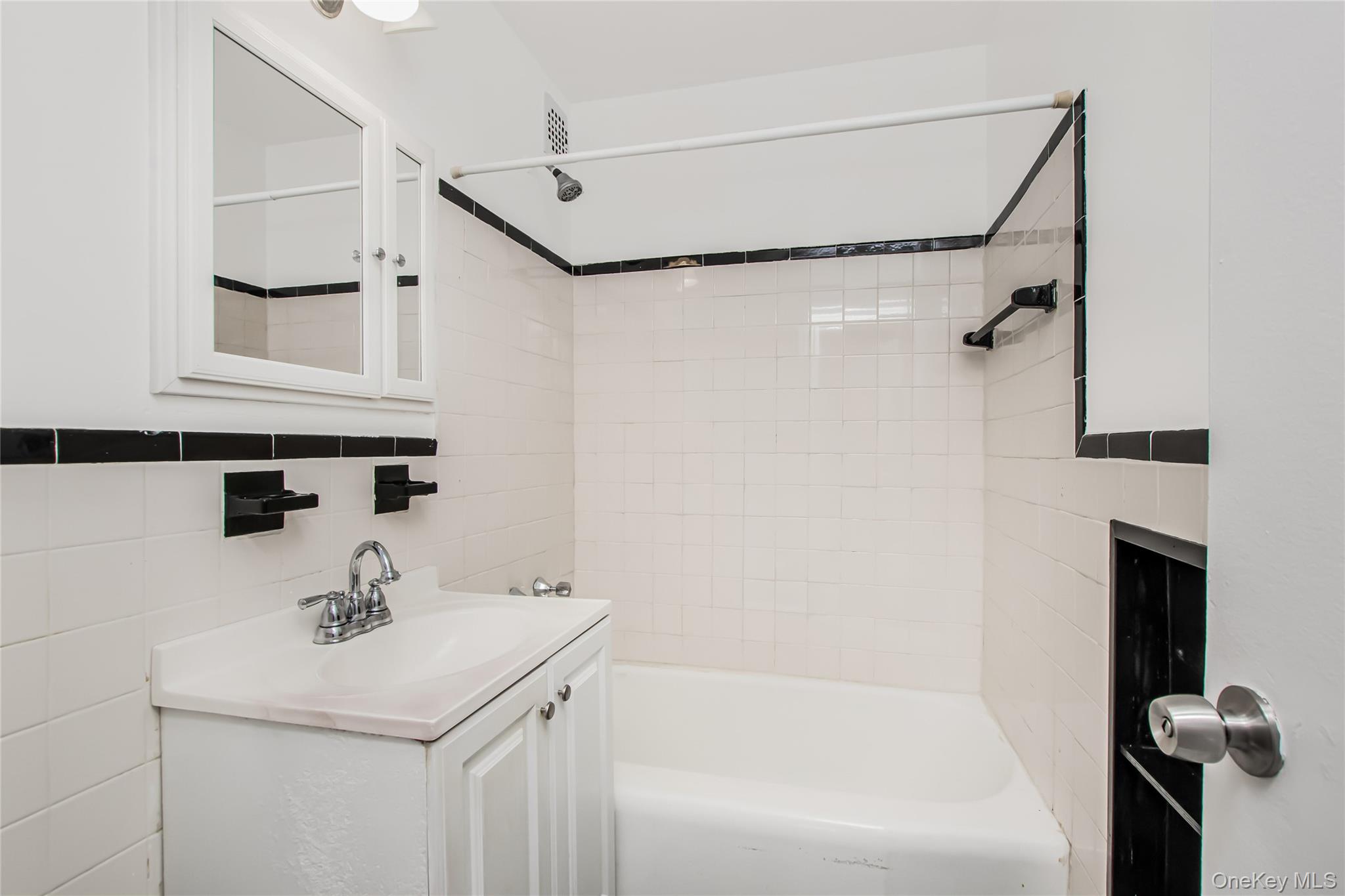 3131 Grand Concourse, Unit 5D Bronx, NY 10468 - Photo 17 of 22 a bathroom with a sink a toilet and shower