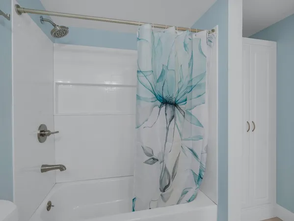 a bathroom with a shower curtain and a window