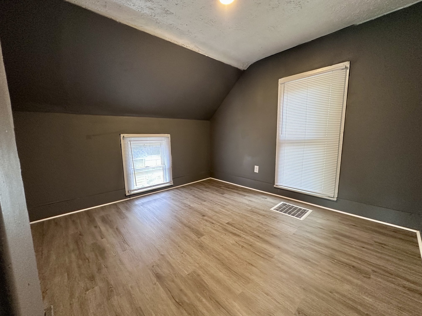 704 West 7th Street Sterling, IL 61081 - Photo 11 of 16 an empty room with wooden floor and windows