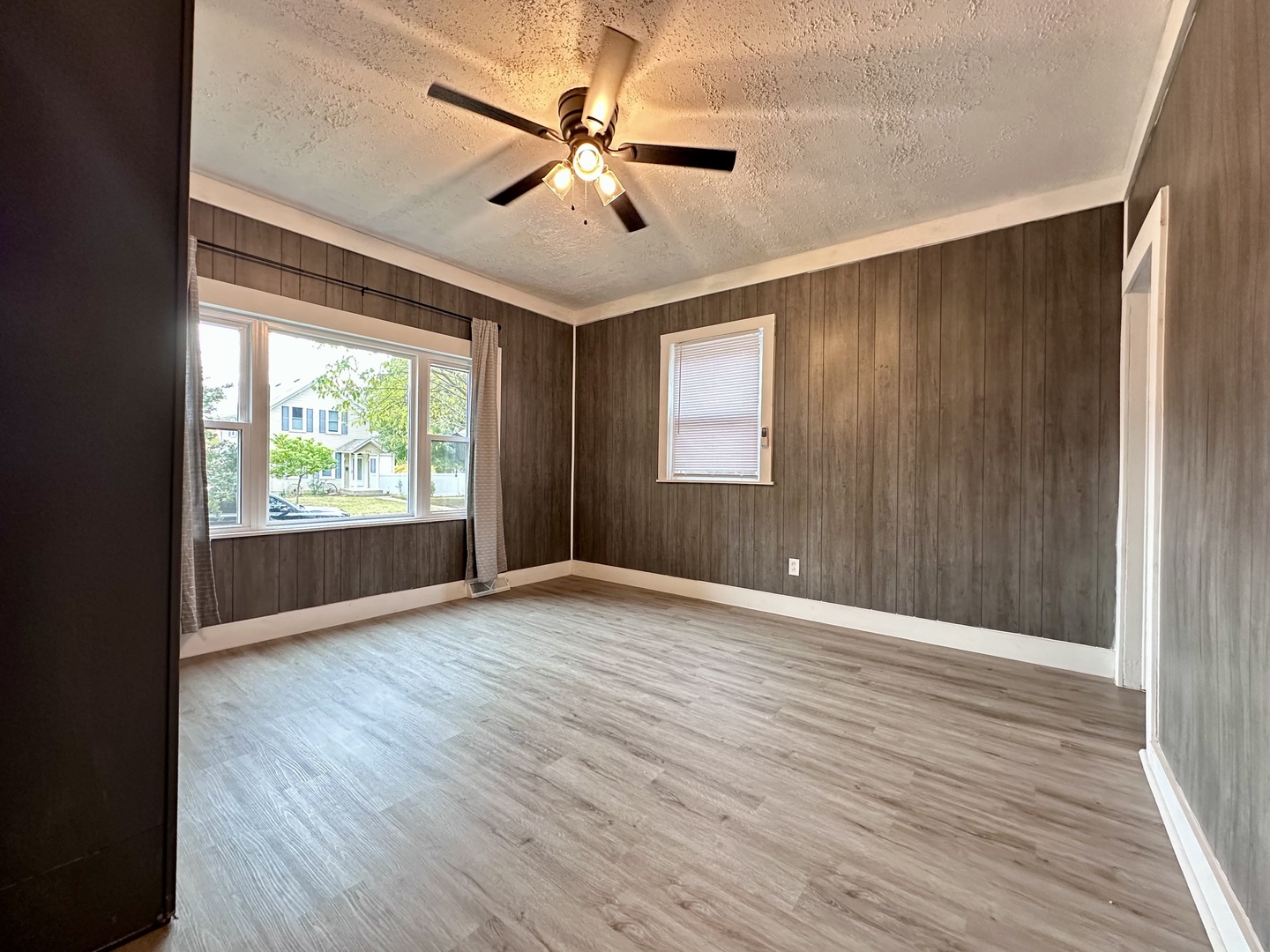 704 West 7th Street Sterling, IL 61081 - Photo 4 of 16 an empty room with wooden floor fan and windows