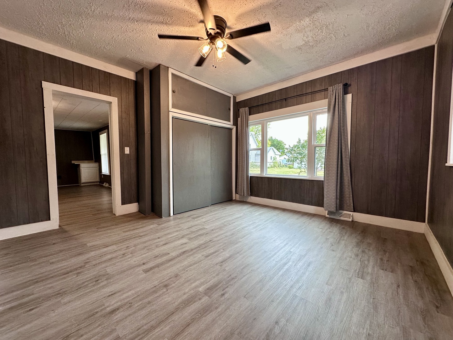 704 West 7th Street Sterling, IL 61081 - Photo 6 of 16 an empty room with wooden floor fan and windows