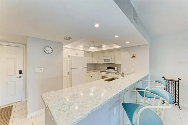 a kitchen with stainless steel appliances granite countertop a sink refrigerator and cabinets