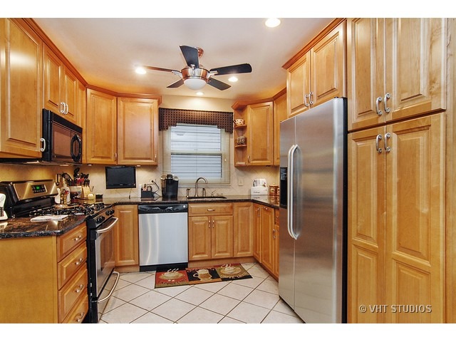 1121 Devonshire Road Buffalo Grove, IL 60089 - Photo 3 of 10 a kitchen with stainless steel appliances granite countertop a refrigerator a stove and a sink