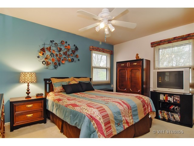 1121 Devonshire Road Buffalo Grove, IL 60089 - Photo 8 of 10 a bedroom with a bed and a flat screen tv