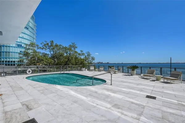 a view of a tennis ground with large trees