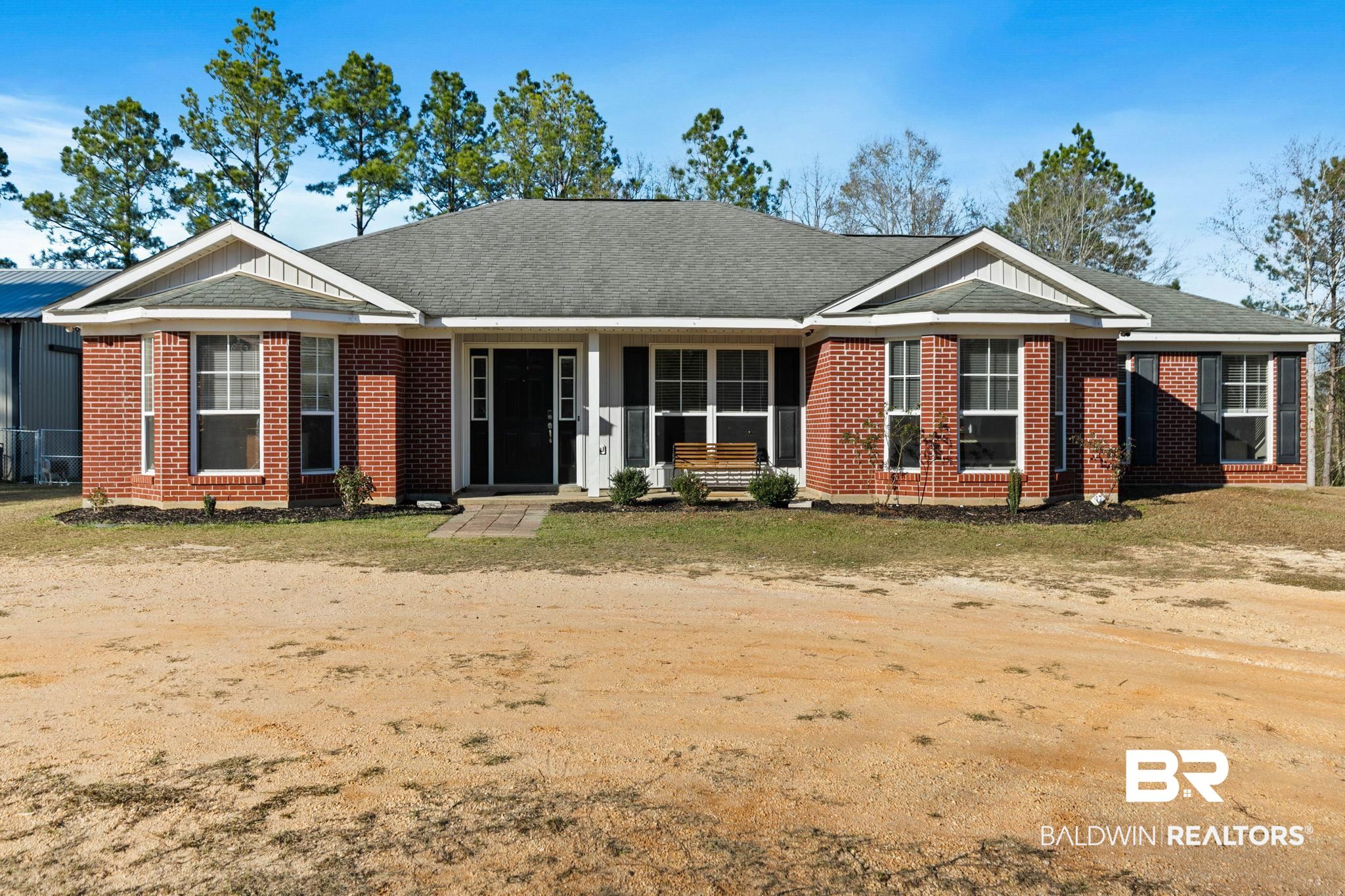 55750 Lottie Road Perdido, AL 36562 - Photo 82 of 84 Ranch-style home featuring a shingled roof, brick siding, and covered porch